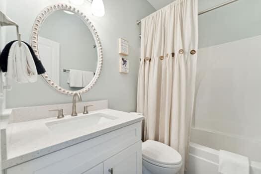 full bathroom featuring vanity, shower / tub combo, and toilet