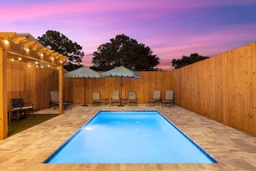 pool at dusk featuring a patio area