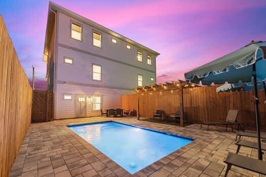 pool at dusk with a patio