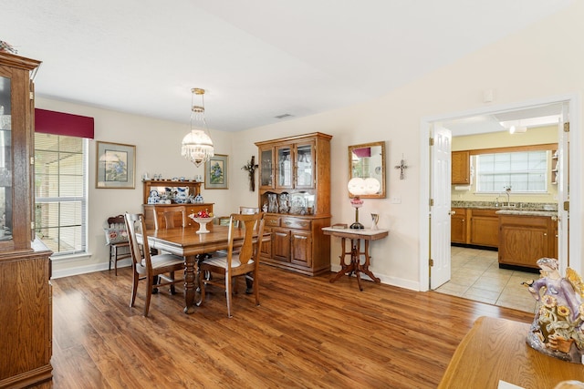 dining space featuring plenty of natural light, a notable chandelier, and light hardwood / wood-style floors