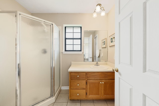 bathroom with a shower with door, tile floors, and vanity