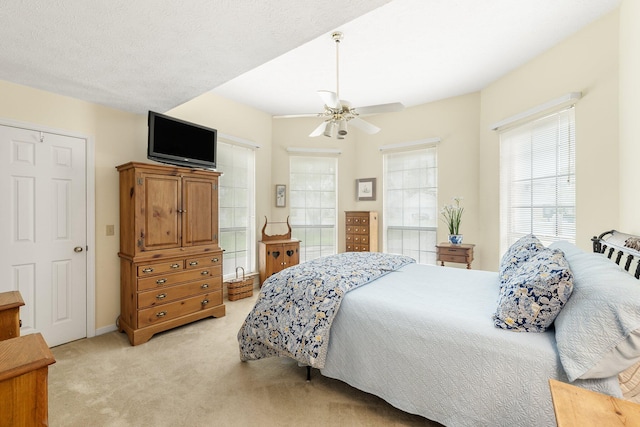 bedroom featuring light colored carpet and ceiling fan