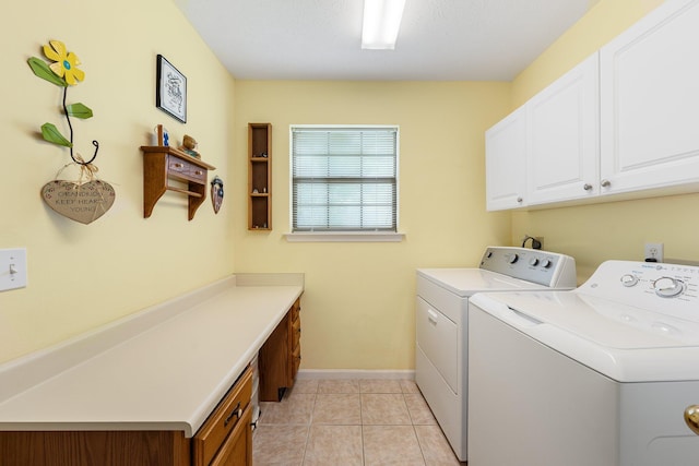 laundry area with cabinets, hookup for an electric dryer, light tile floors, and washing machine and clothes dryer