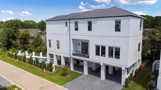 back of house with a yard and a balcony