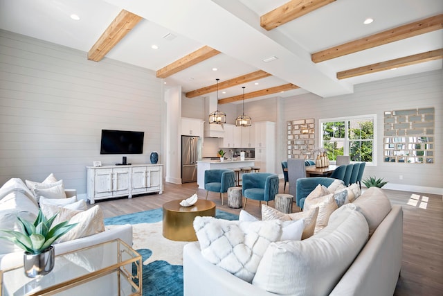 living room with beam ceiling and dark wood-type flooring