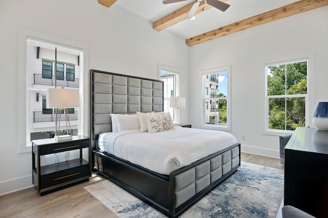 bedroom with beamed ceiling, ceiling fan, and light hardwood / wood-style flooring