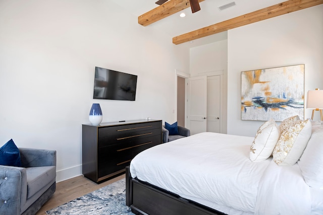 bedroom featuring beamed ceiling, ceiling fan, and light hardwood / wood-style floors