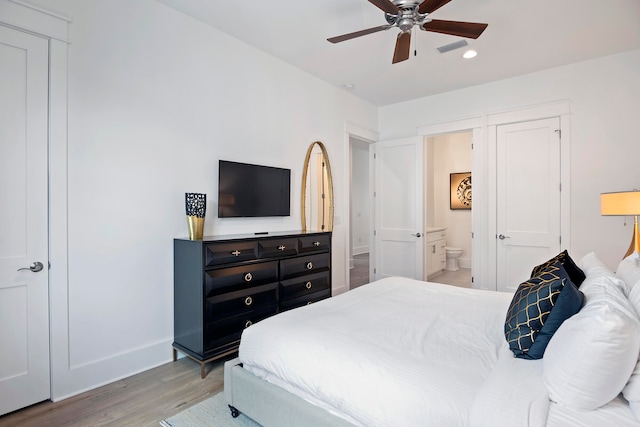 bedroom with ceiling fan, ensuite bathroom, and hardwood / wood-style floors