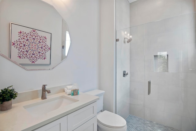 bathroom with a shower with shower door, toilet, and vanity