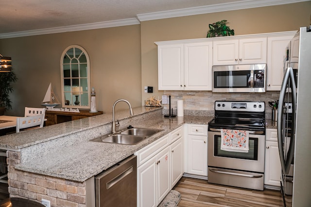 kitchen featuring stainless steel appliances, kitchen peninsula, white cabinets, and sink