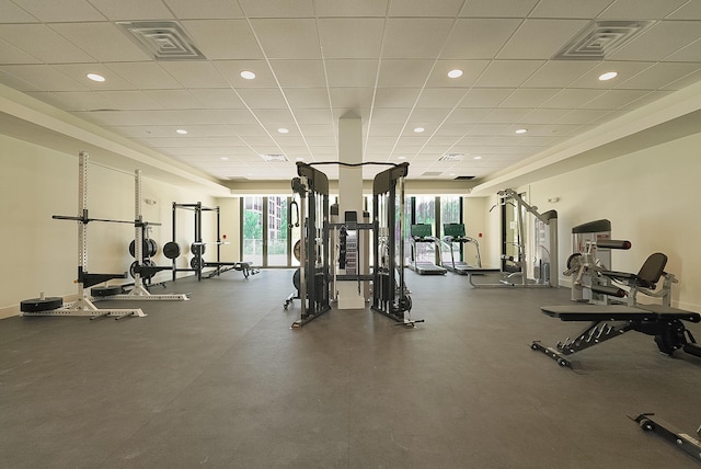 workout area with baseboards, visible vents, and a drop ceiling