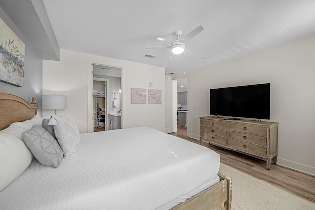 bedroom with baseboards, visible vents, connected bathroom, ceiling fan, and wood finished floors