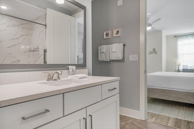 bathroom featuring a shower, connected bathroom, ceiling fan, vanity, and baseboards