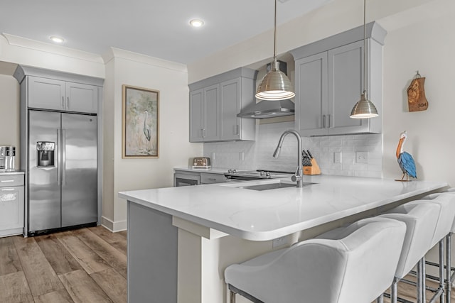 kitchen featuring gray cabinetry, a sink, a peninsula, and stainless steel fridge with ice dispenser