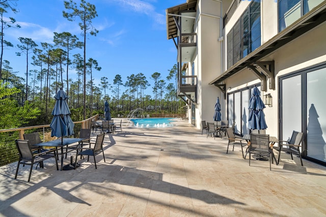 view of patio with outdoor dining area and a fenced in pool