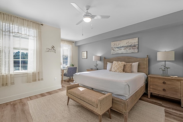 bedroom with a ceiling fan, baseboards, and wood finished floors