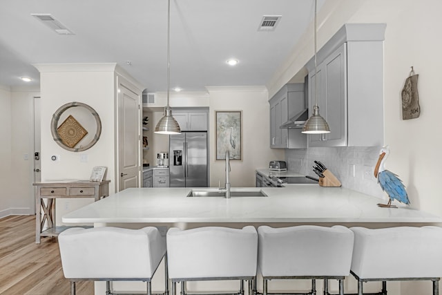 kitchen featuring visible vents, gray cabinetry, a sink, a peninsula, and stainless steel fridge with ice dispenser