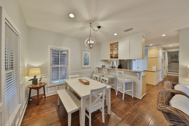 dining room featuring a notable chandelier, baseboard heating, and dark wood-type flooring