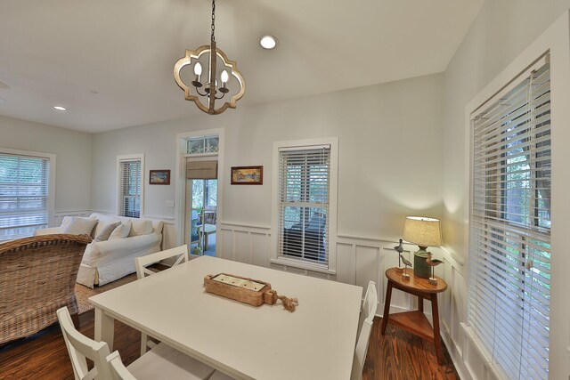 dining area with plenty of natural light, a notable chandelier, and dark wood-type flooring