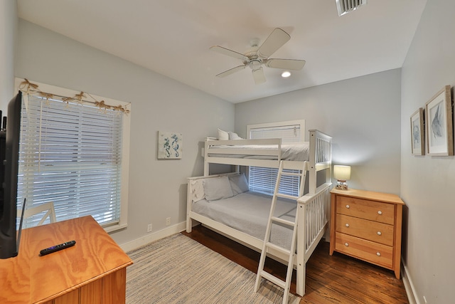 bedroom with dark hardwood / wood-style flooring and ceiling fan