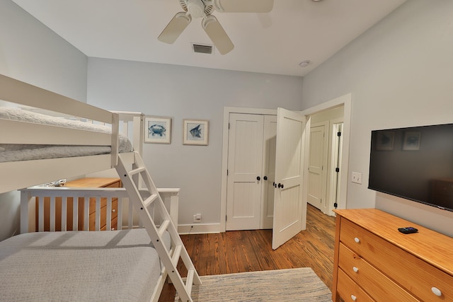 bedroom with dark wood-type flooring, a closet, and ceiling fan