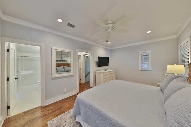 bedroom featuring crown molding, dark wood-type flooring, ensuite bathroom, and ceiling fan