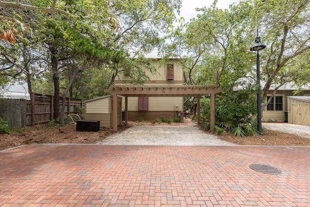 view of front of home featuring a pergola and a shed