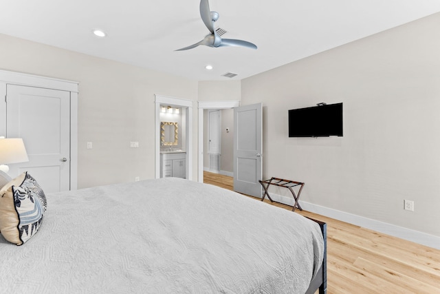 bedroom with light hardwood / wood-style floors, ensuite bathroom, and ceiling fan