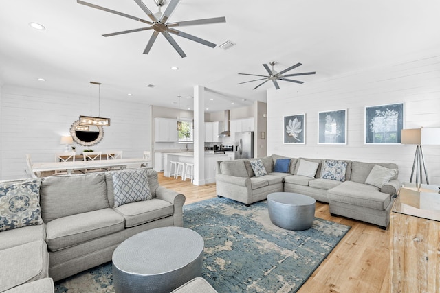 living room with ceiling fan and light wood-type flooring