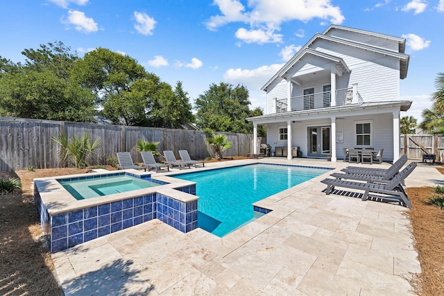 view of swimming pool featuring a patio area and an in ground hot tub