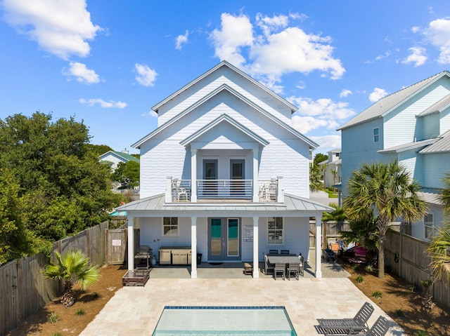 back of house featuring a patio area, french doors, an empty pool, and a balcony