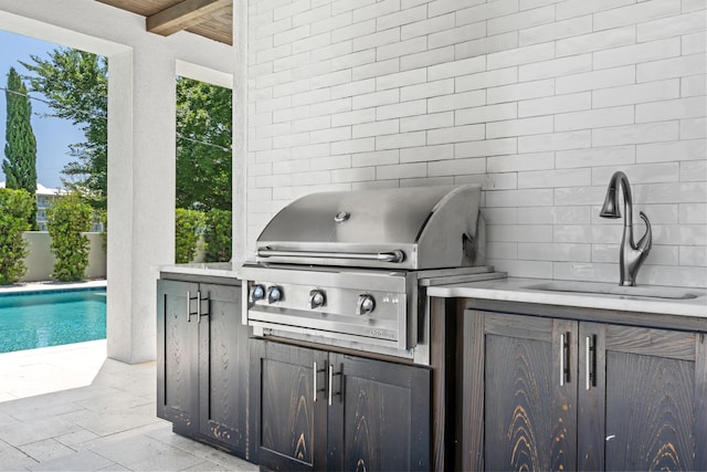 view of patio / terrace with sink, a grill, and a fenced in pool