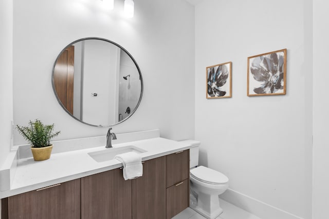 bathroom featuring tile flooring, vanity, and toilet