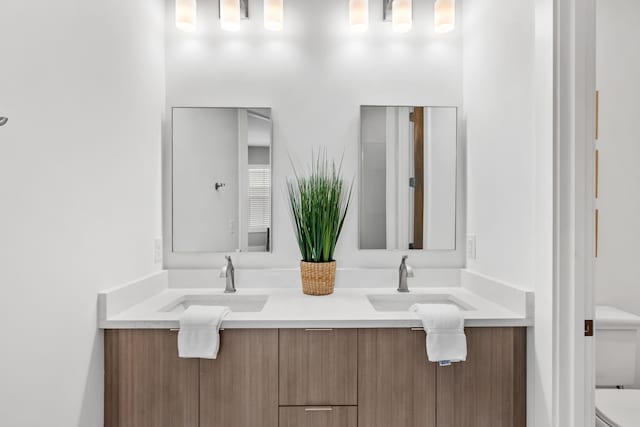 bathroom featuring double vanity and toilet