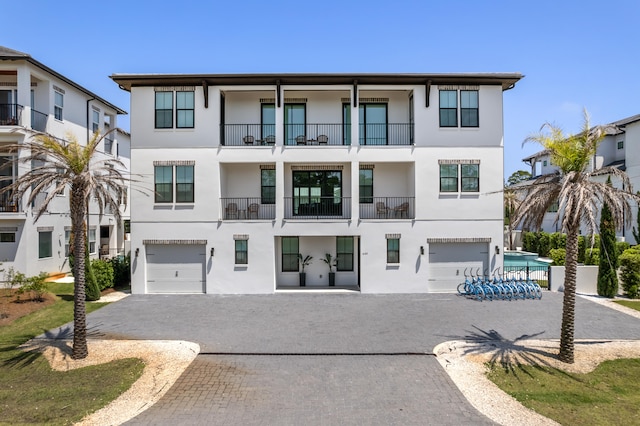 view of front of property featuring a garage and a balcony