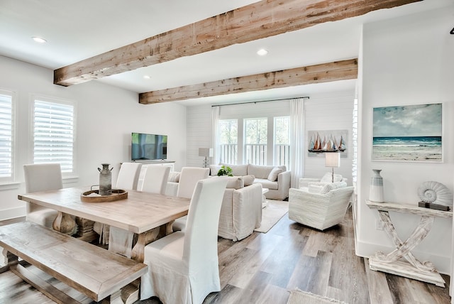 dining area with beamed ceiling and hardwood / wood-style floors