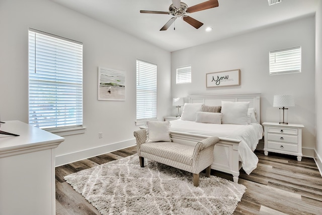 bedroom with ceiling fan, multiple windows, and wood-type flooring