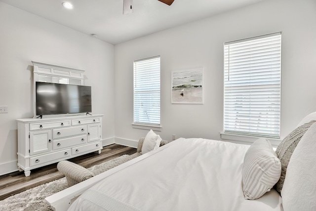 bedroom with dark hardwood / wood-style flooring and ceiling fan