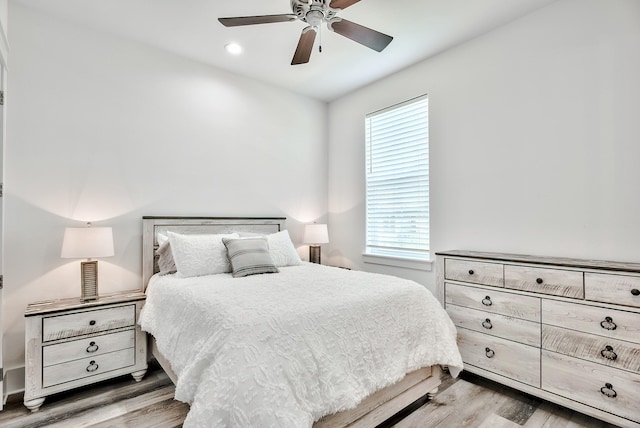 bedroom featuring wood-type flooring, ceiling fan, and multiple windows