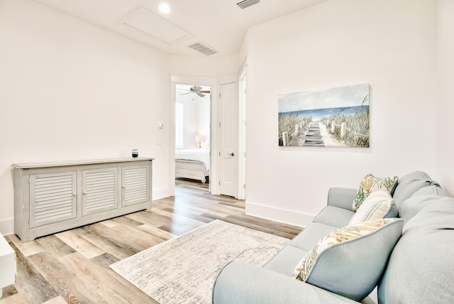 living room with ceiling fan and light hardwood / wood-style flooring