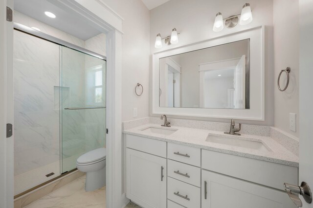 bathroom with a shower with shower door, tile floors, oversized vanity, toilet, and dual sinks