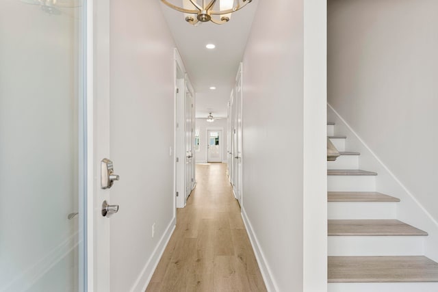 hallway with a chandelier and light hardwood / wood-style flooring