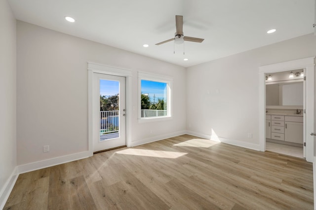 unfurnished bedroom with ceiling fan, light wood-type flooring, ensuite bathroom, access to exterior, and sink