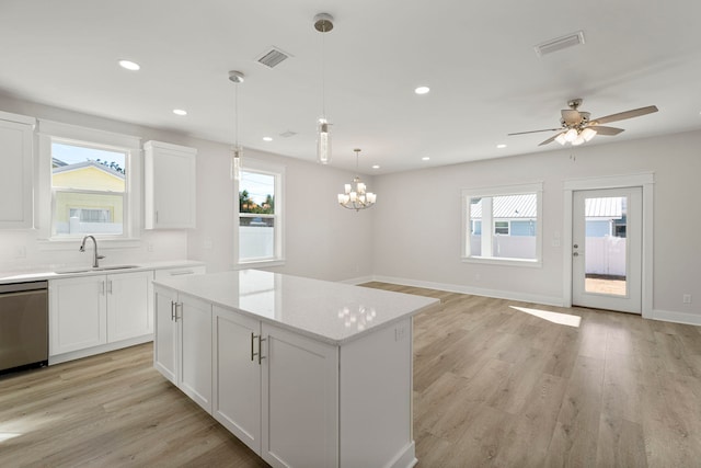 kitchen with white cabinets, sink, stainless steel dishwasher, and light hardwood / wood-style floors