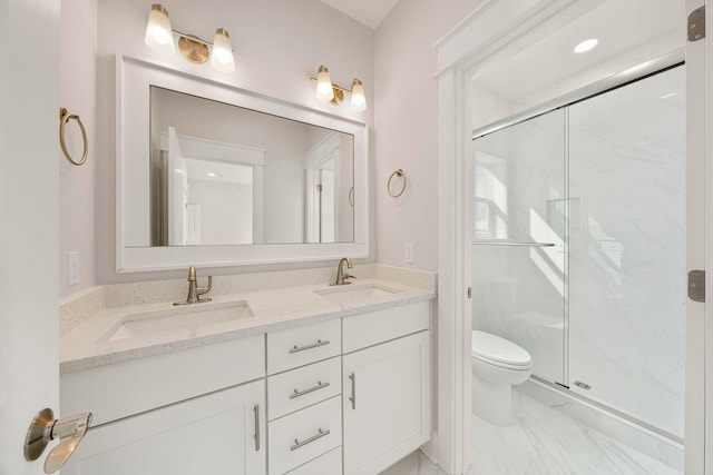 bathroom featuring vanity with extensive cabinet space, toilet, tile floors, a shower with shower door, and double sink