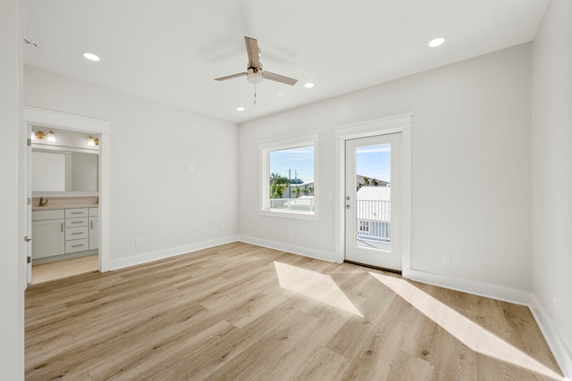 unfurnished bedroom with ensuite bathroom, ceiling fan, light wood-type flooring, and access to outside