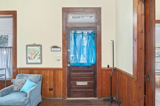 entrance foyer with wood walls and dark hardwood / wood-style flooring