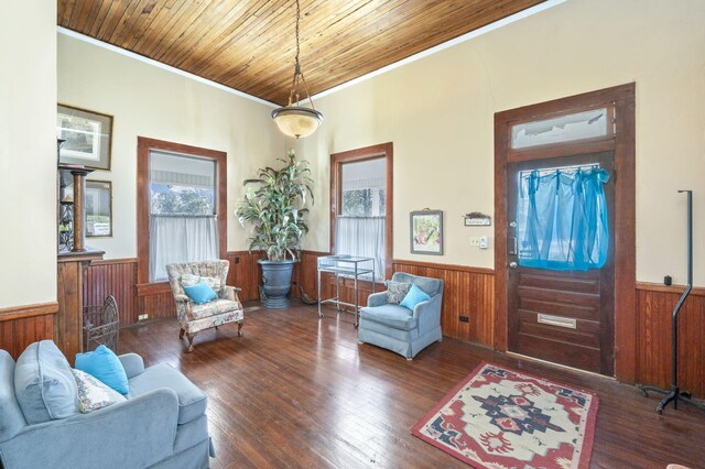 interior space with crown molding, dark hardwood / wood-style flooring, wood ceiling, and wood walls