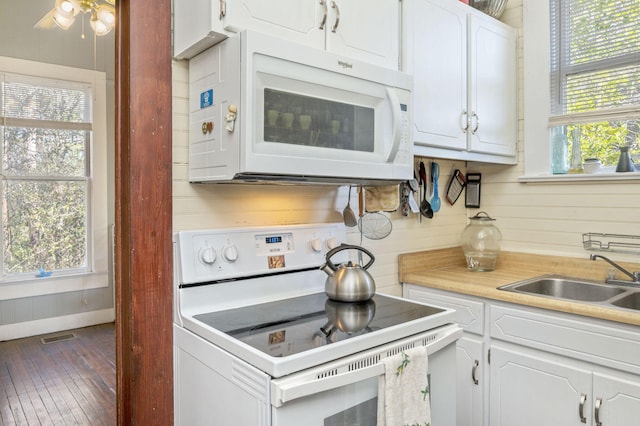 kitchen with plenty of natural light, white cabinetry, white appliances, and sink