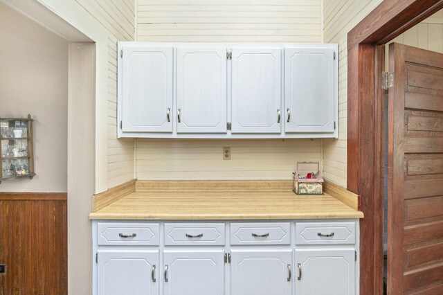 kitchen with white cabinets and wood walls